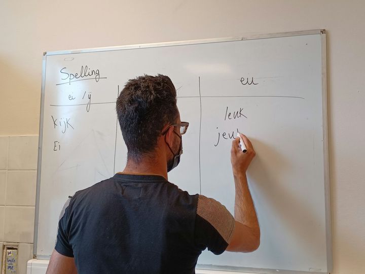 cursist schrijft aan een whiteboard in de klas