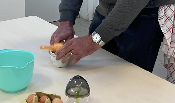 cursist leert eieren breken en scheiden met een hulpmiddel
